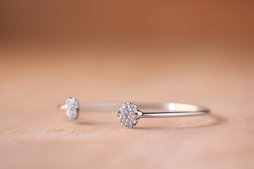 Silver Gemstone Bangle Bracelets on Wooden Surface