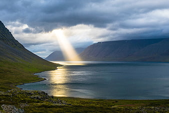 Dramatic Sunbeam Over Mountain Fjord Landscape