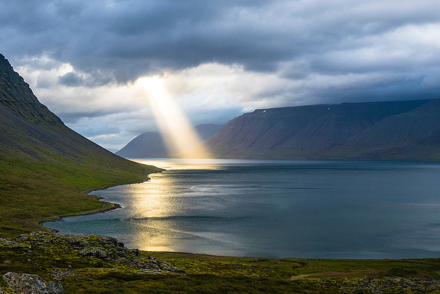 Dramatic Sunbeam Over Mountain Fjord Landscape
