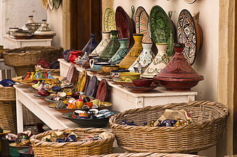 Colorful Moroccan Pottery, Tajines, and Woven Baskets in Market Shop
