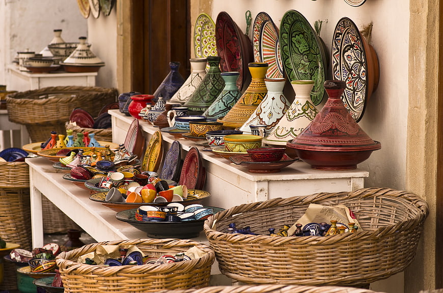 Colorful Moroccan Pottery, Tajines, and Woven Baskets in Market Shop