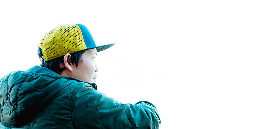 Man in Yellow Cap Looking Right on White Background