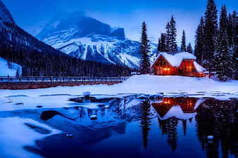 Cozy Log Cabin with Warm Lights Reflected in Frozen Lake at Dusk