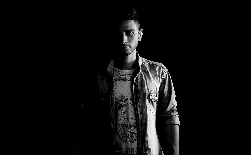 Dramatic black and white portrait of a young man in denim