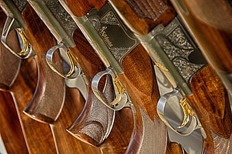 Close-up of ornate vintage shotguns with engraved metal and wood