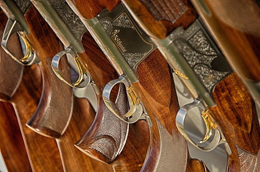 Close-up of ornate vintage shotguns with engraved metal and wood