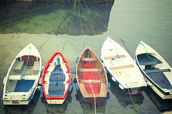 High angle view of five colorful boats docked in calm water