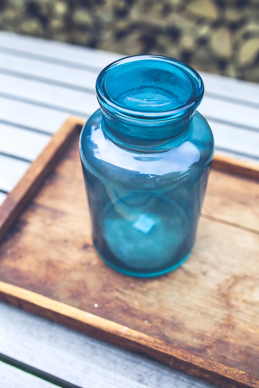 Blue glass jar on wooden tray
