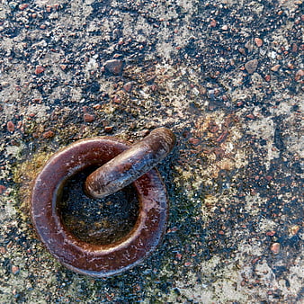 Rusty metal ring on wet concrete texture background