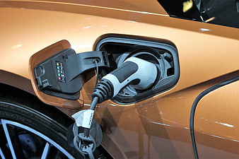 Close-up of orange electric car charging port with plug