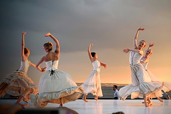 Ballet dancers performing on stage at sunset