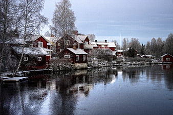 Traditional Red Cottages on a Frozen Lake in Winter Sweden