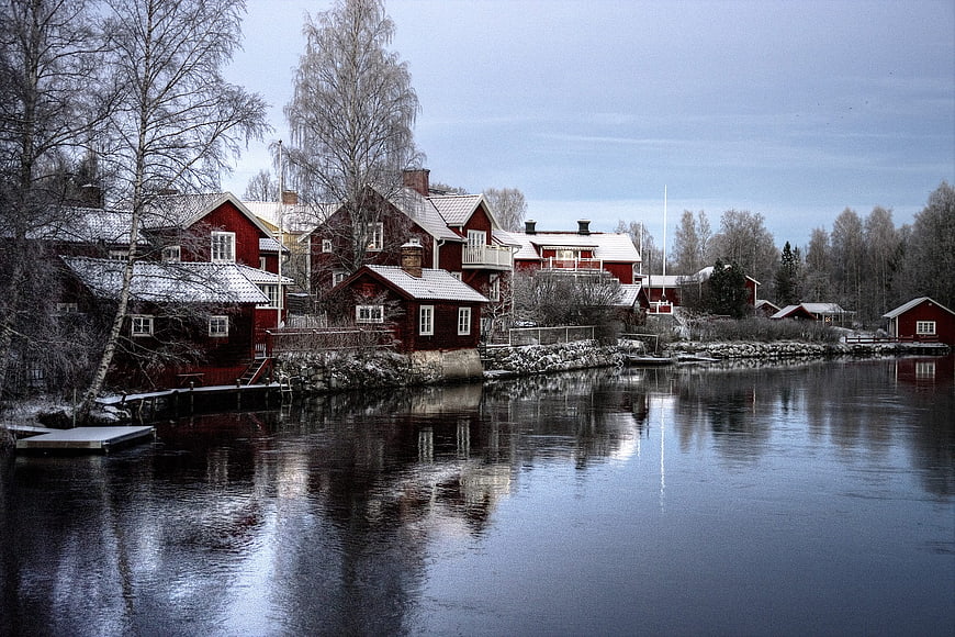 Traditional Red Cottages on a Frozen Lake in Winter Sweden