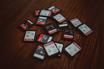 Scattered SanDisk Memory Cards On Dark Wooden Table