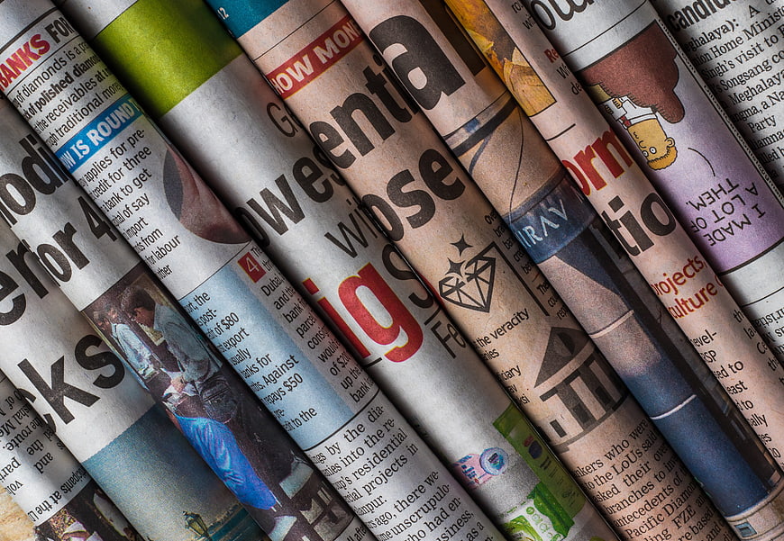 Close-up of rolled newspapers with visible headlines and text