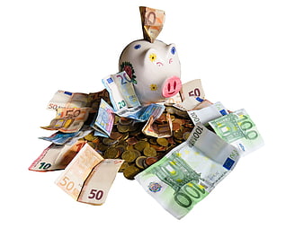 White ceramic piggy bank overflowing with euro banknotes and coins on white background