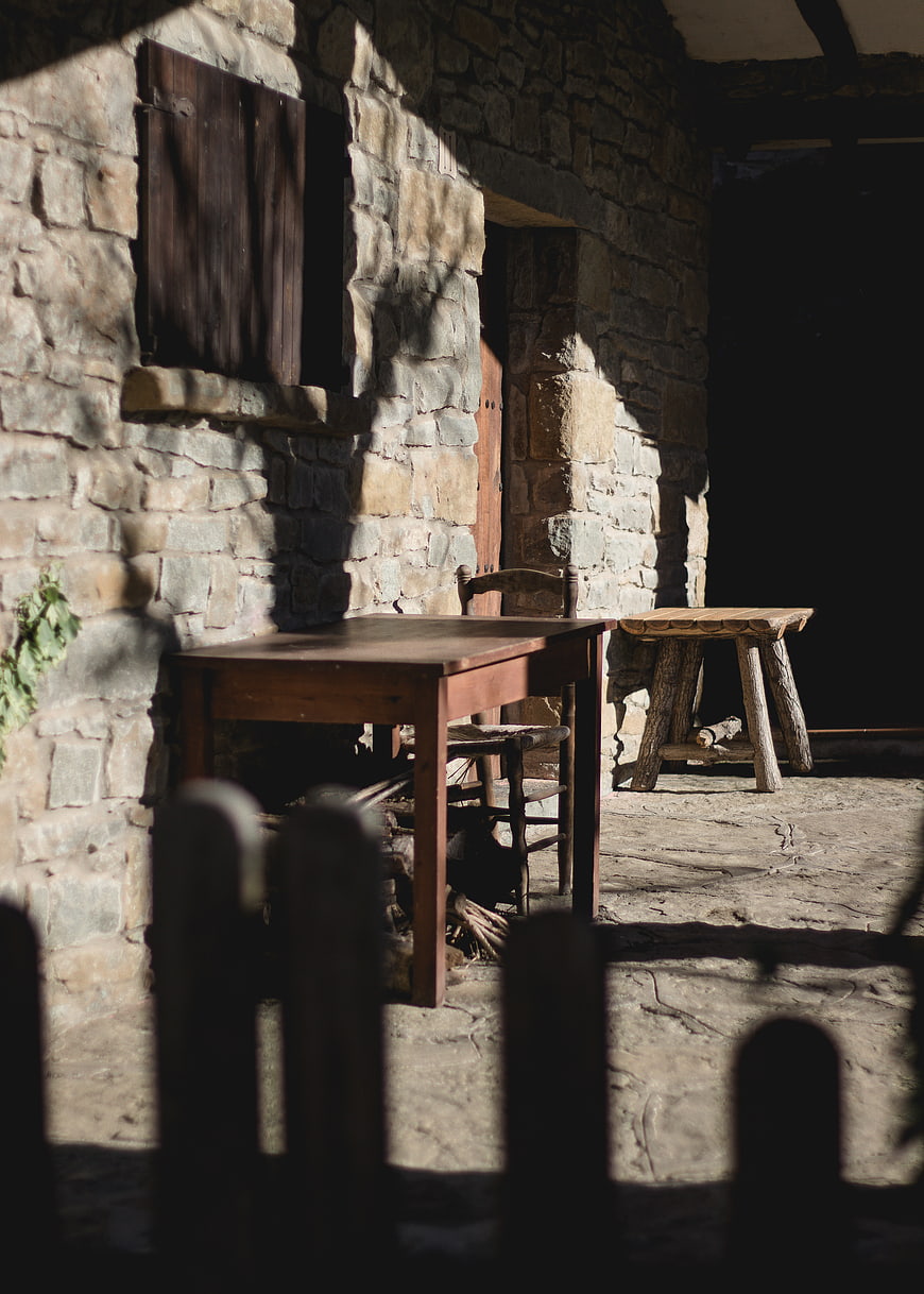 Rustic Stone Patio with Wooden Table and Stool