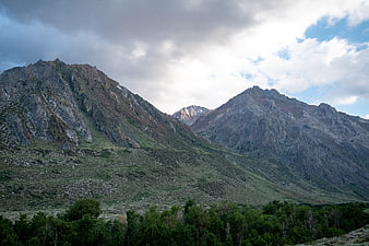 Dramatic Rocky Mountain Peaks with Forest and Cloudy Sky
