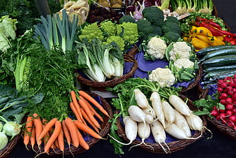 Fresh Organic Vegetables Displayed In Wicker Baskets At Market Stall