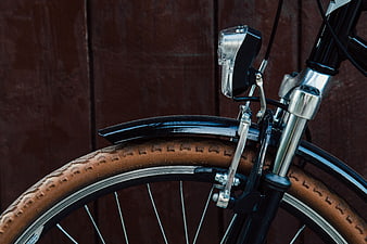 Close-up of Vintage Bicycle Wheel with Brown Tire and Chrome Fork