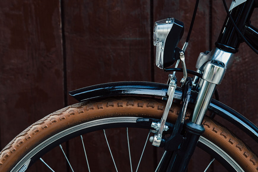 Close-up of Vintage Bicycle Wheel with Brown Tire and Chrome Fork