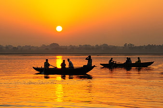 Silhouettes of Boats on River at Golden Sunset