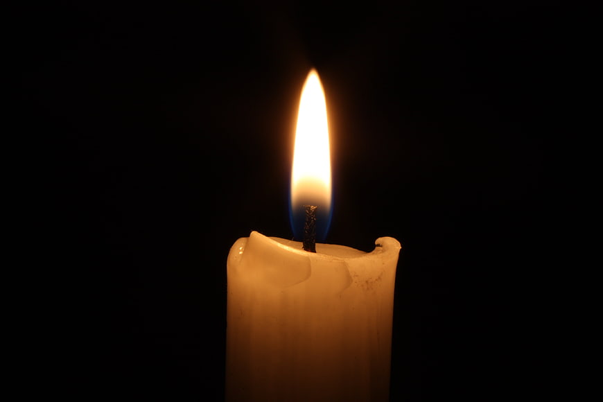 Lit White Candle Flame Close Up On Black Background