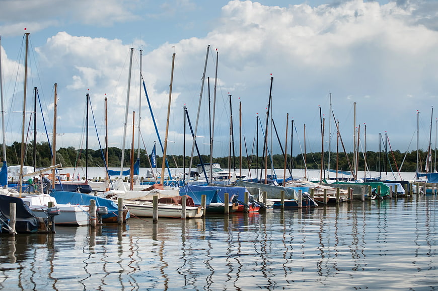Sailboats docked in marina with reflections on water