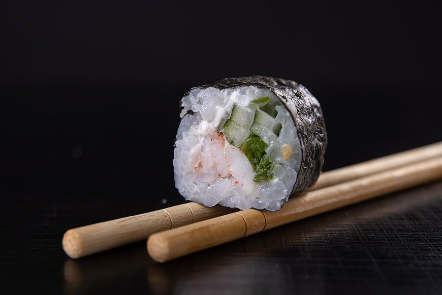 Close-up of Sushi Maki Roll on Chopsticks