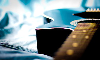 Close-up of Blue Acoustic Guitar on Bed