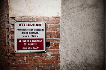Italian parking warning sign on weathered brick wall