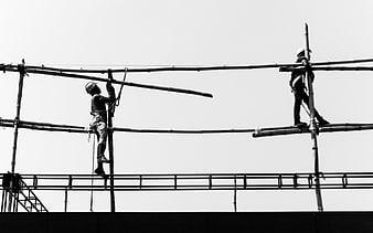 Construction workers on bamboo scaffolding black and white
