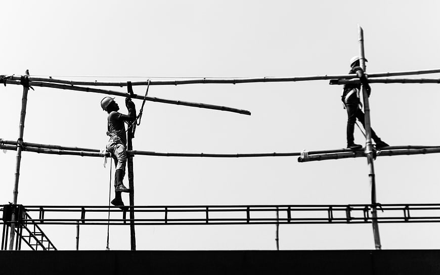 Construction workers on bamboo scaffolding black and white