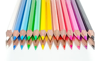 Colorful wooden pencils arranged in a rainbow row on white