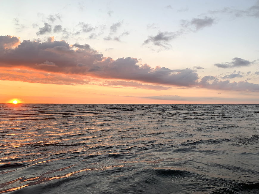 Serene Ocean Sunset with Golden Sun and Clouds