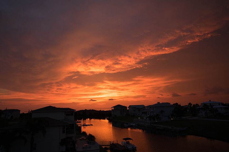 Vibrant Orange Sunset Over Waterfront Residential Canal