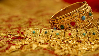Traditional Gold Jewelry with Gemstones on Red Fabric