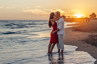 Romantic couple kissing on beach at sunset
