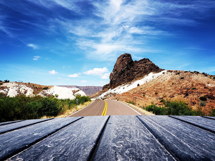 Scenic Desert Road with Rocky Mountain and Blue Sky