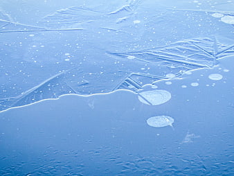 Close-up of frozen ice surface with trapped air bubbles and cracks