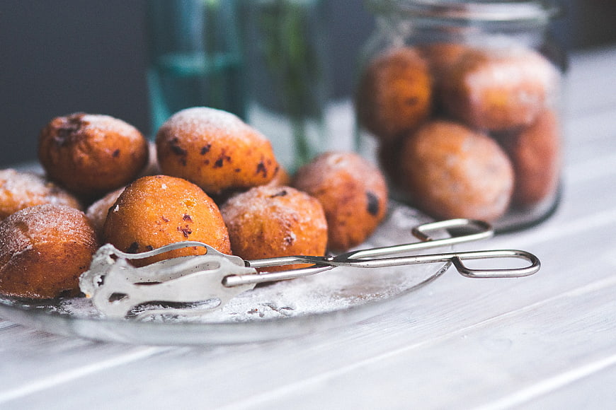 Homemade powdered doughnut holes on glass plate
