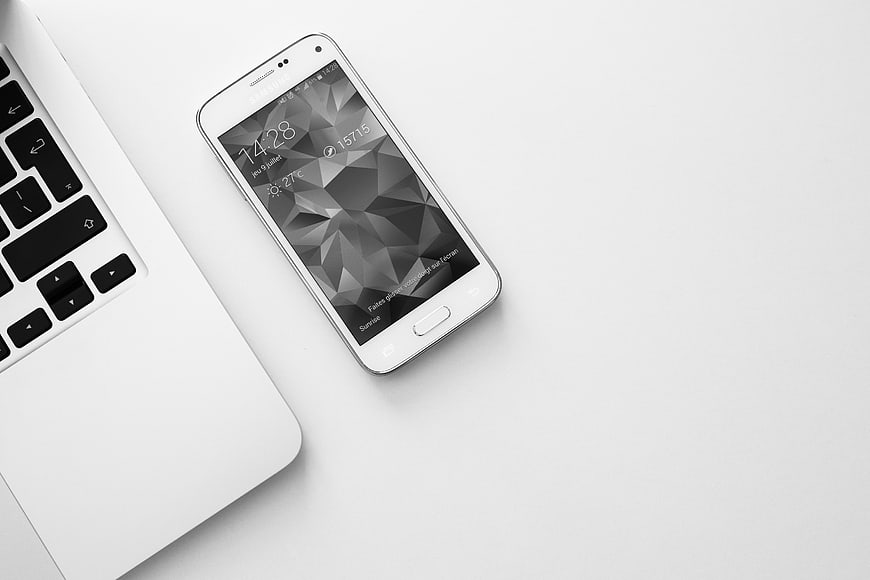 White Smartphone and Laptop on Minimalist White Desk