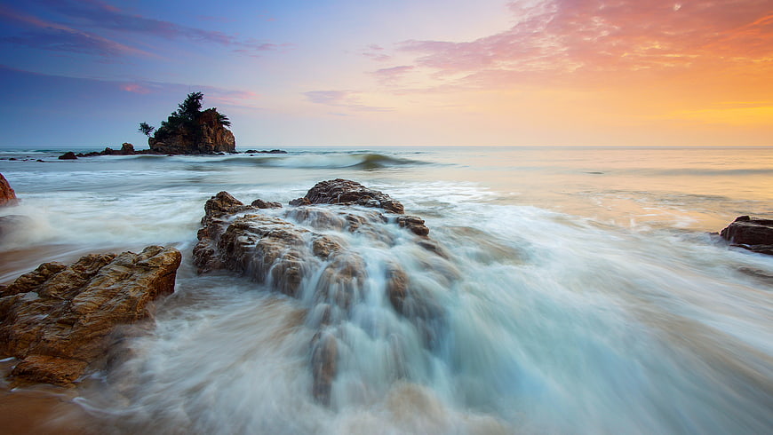 Long Exposure Sunset Ocean Waves Crashing on Rocky Coastline