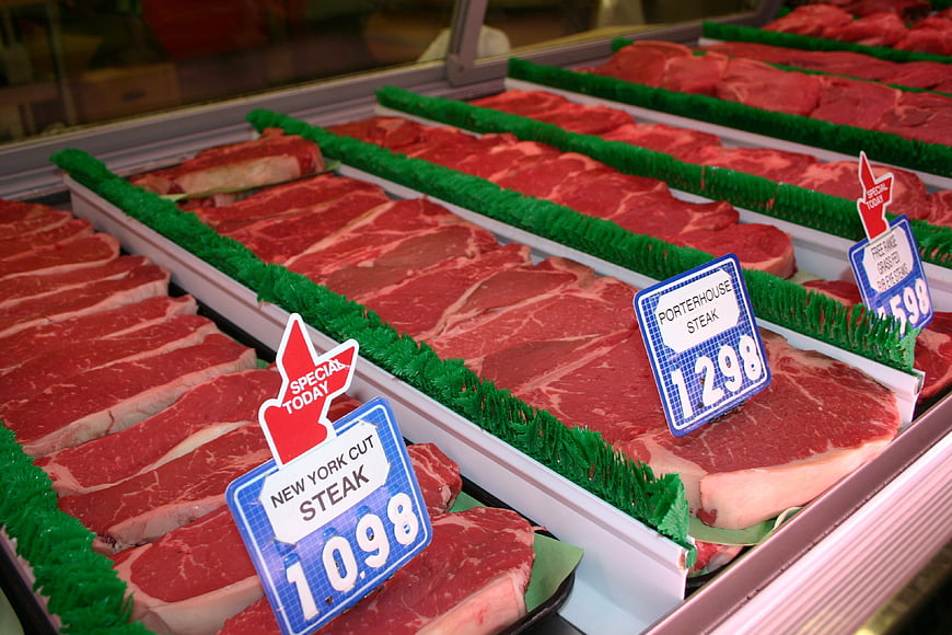 Fresh raw steaks on display in a supermarket meat counter