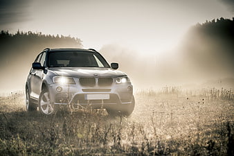 Silver SUV Driving Through Foggy Autumn Field