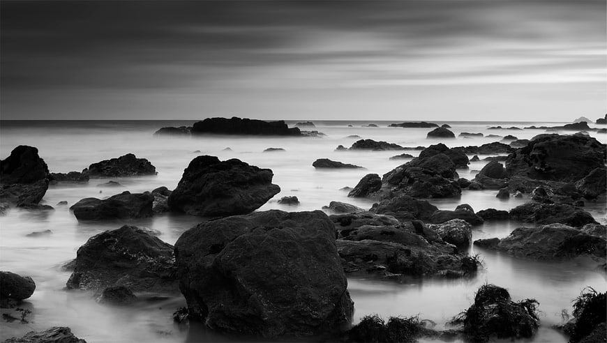 Black and white long exposure rocky coastline with misty ocean