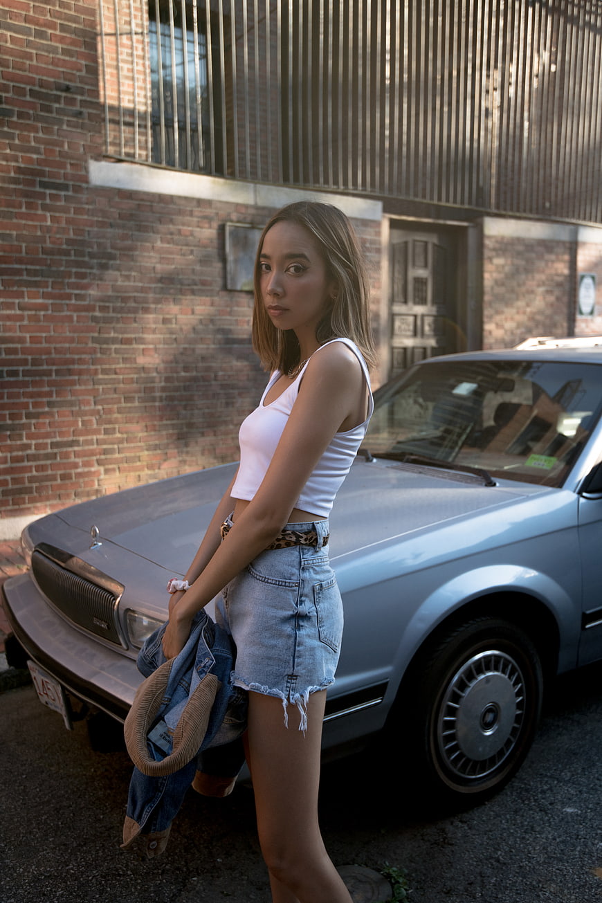 Stylish Woman Leaning on Vintage Silver Car in Urban Setting