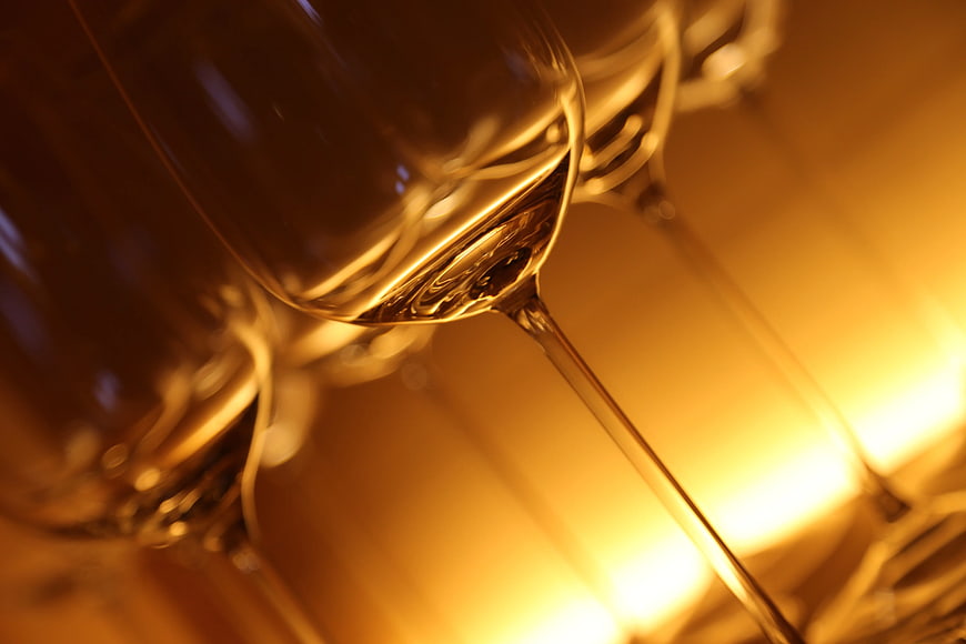 Close-up of elegant wine glasses with golden lighting
