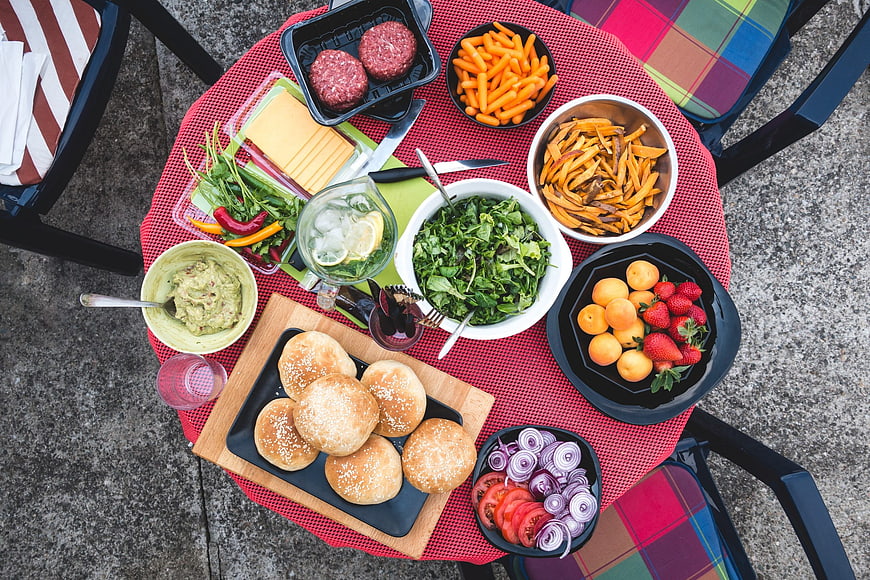 Top View of Barbecue Ingredients and Sides on Outdoor Table