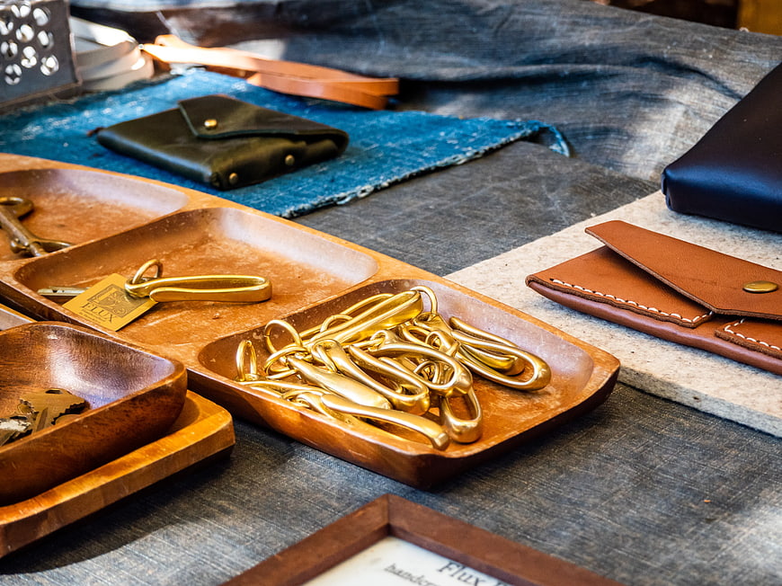 Handcrafted Leather Wallets and Brass Hardware on Wooden Tray